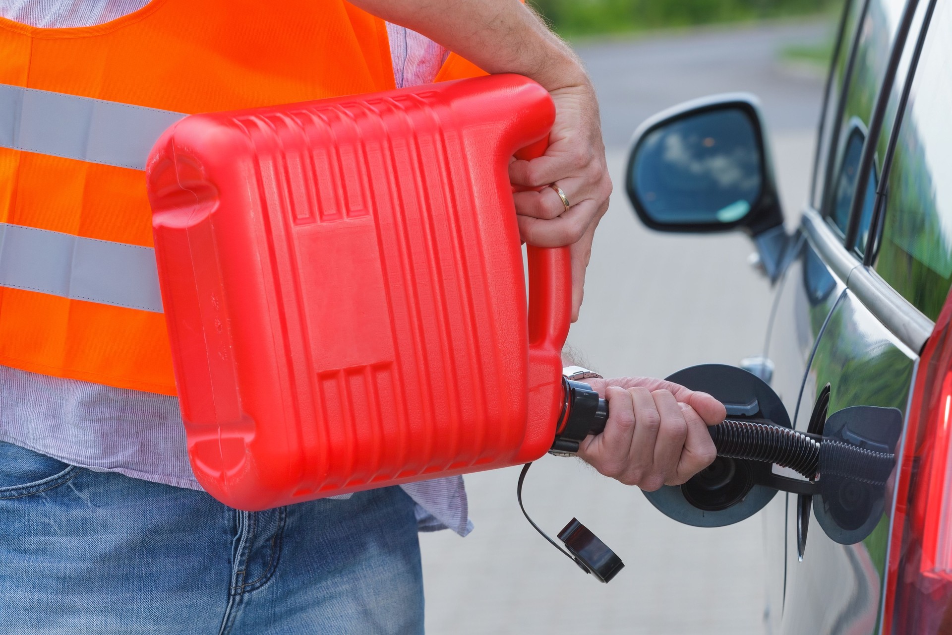 El conductor llena el combustible en un tanque de coche vacío de bote.